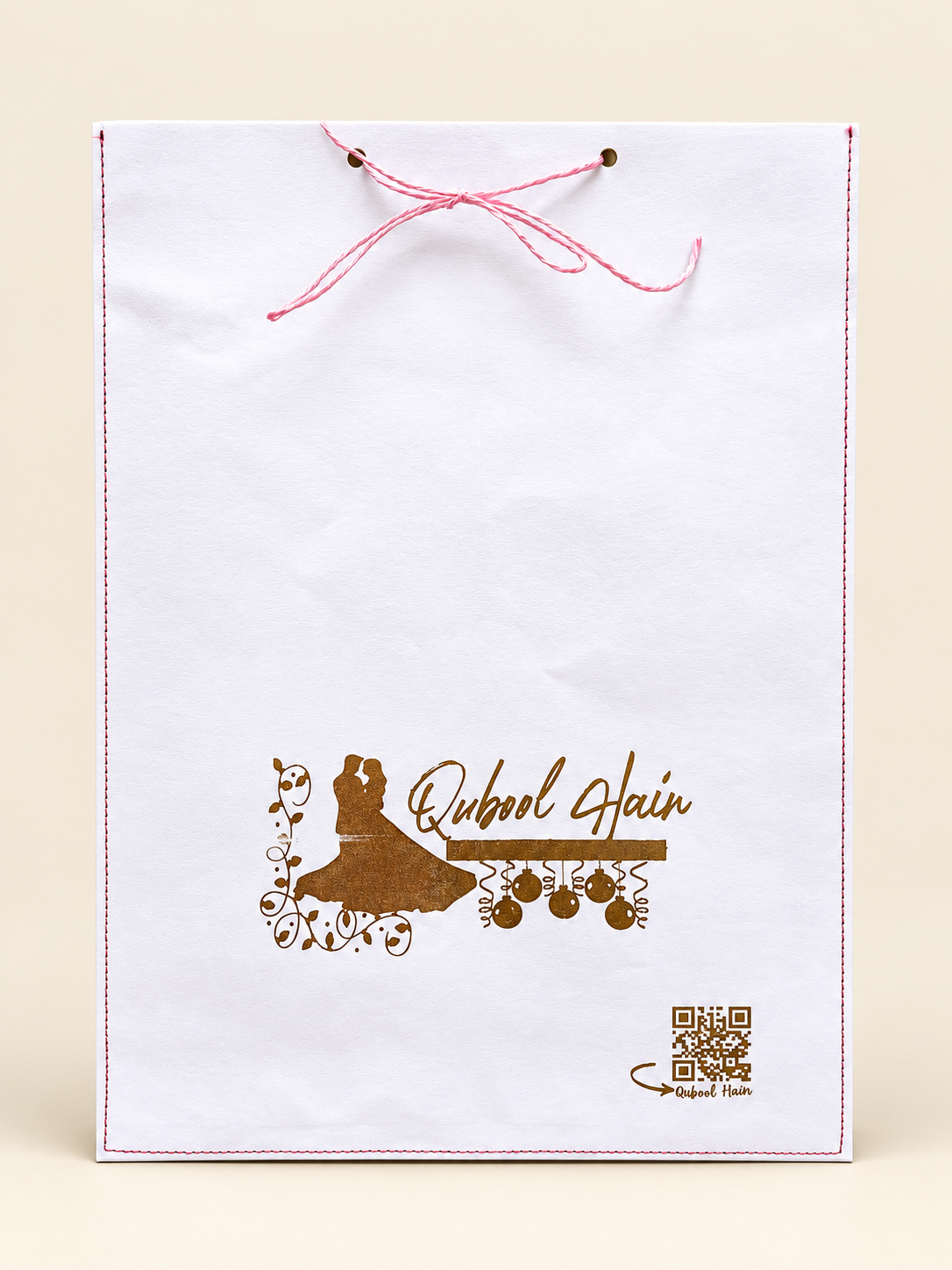 White Qubool Hain envelope with gold branding, stitched edges and pink thread tie